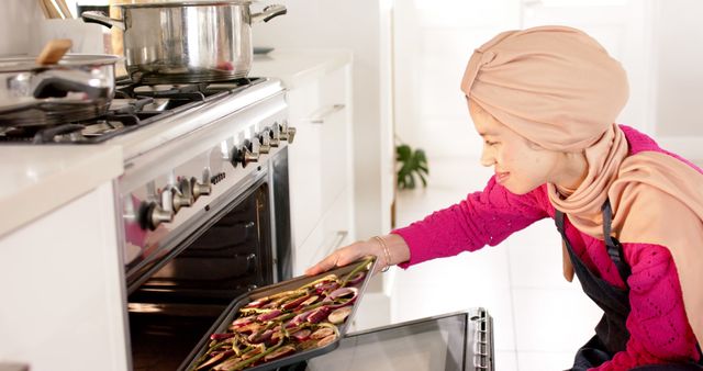 Woman Baking Vegetables in Oven while Wearing Hijab - Download Free Stock Images Pikwizard.com