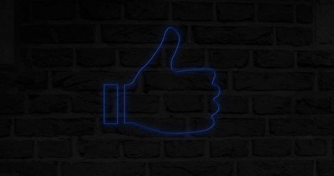 Glowing blue thumbs up icon on brick wall symbolizing social media approval