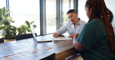 Multiracial Professionals Discussing Contract in Modern Office