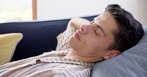 Young man resting on couch with peaceful expression
