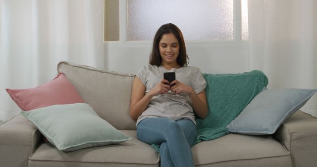 Young Woman Relaxing on Couch and Texting on Mobile Phone - Download Free Stock Images Pikwizard.com