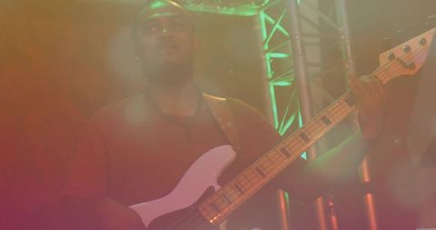 Bassist Performing on Stage with Colorful Haze Lighting