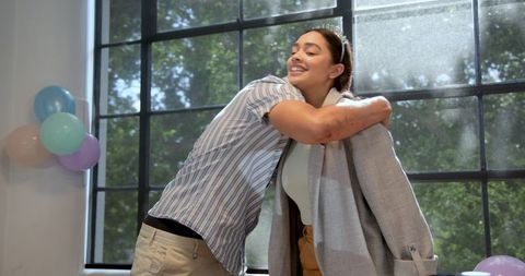 Colleagues Celebrating Birthday with Hugs in Office