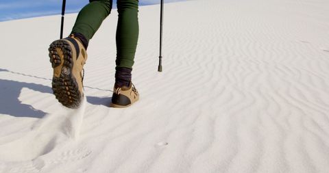 Hiker's boots trekking through pristine sand dunes
