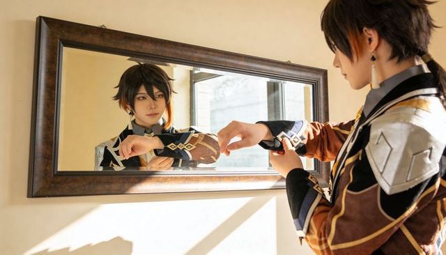 Cosplayer adjusting ornate fantasy armor cuff while inspecting reflection in wooden mirror