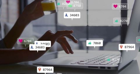 Hands typing on laptop with floating social media notifications for marketing