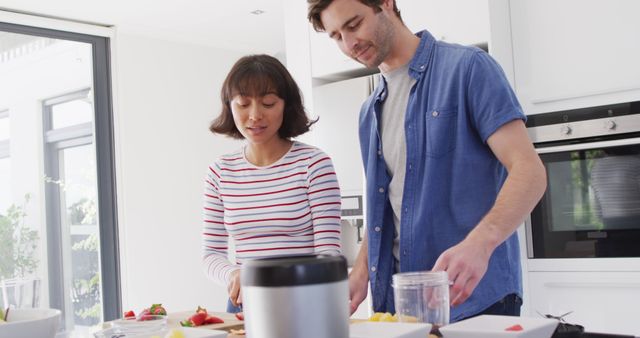 Image of happy diverse couple preparing meal together in kitchen. Love, relationship and spending quality time together concept.