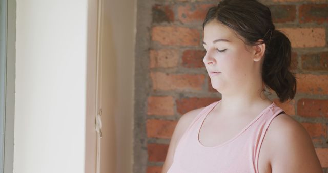 Woman Exercising Mindfulness Indoors Near Brick Wall - Download Free Stock Images Pikwizard.com