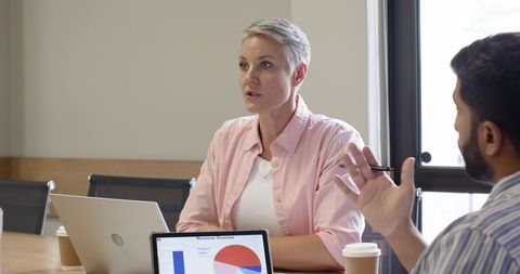 Business colleagues discussing revenue sources in modern workspace