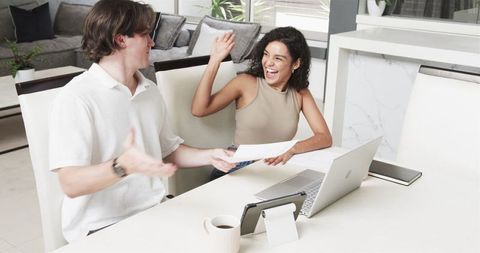 Happy Multiracial Couple Working Together at Home