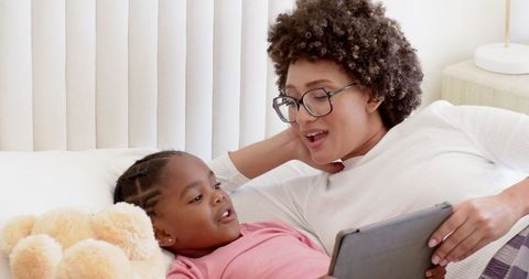 Mother and Daughter Bonding While Reading Tablet Together