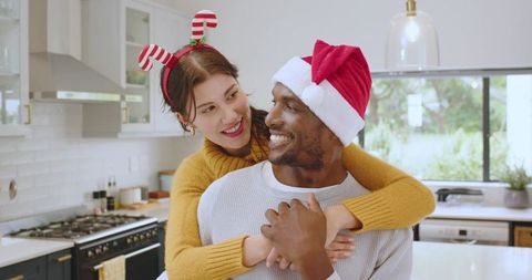 Festive Couple Embracing in Modern Kitchen with Holiday Accessories