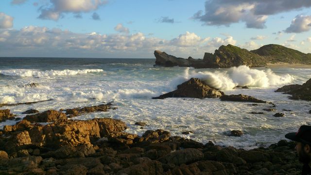 Waves crashing on rocky seaside under cloudy sky - Download Free Stock Photos Pikwizard.com