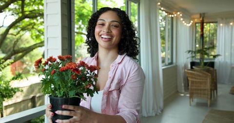 Smiling Woman with Chrysanthemums on Serene Rustic Porch