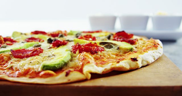 Close-Up of Freshly Baked Veggie Pizza with Avocado and Sun-Dried Tomatoes - Download Free Stock Images Pikwizard.com