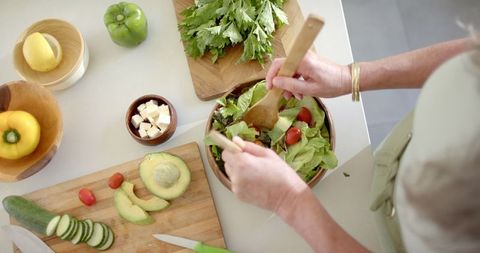 Mature Woman Preparing Healthy Fresh Vegetable Salad