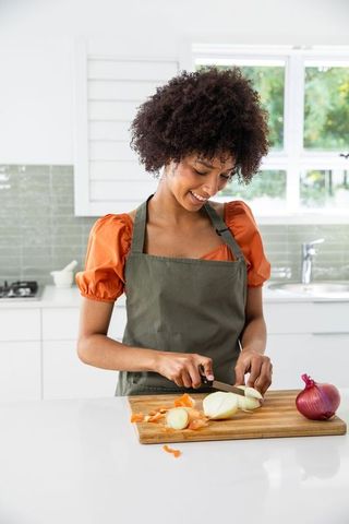 African American Woman Chopping Onions in Modern Kitchen
