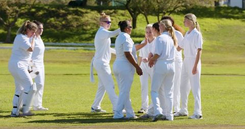 Diverse Female Cricket Team Celebrating Unity on Pitch