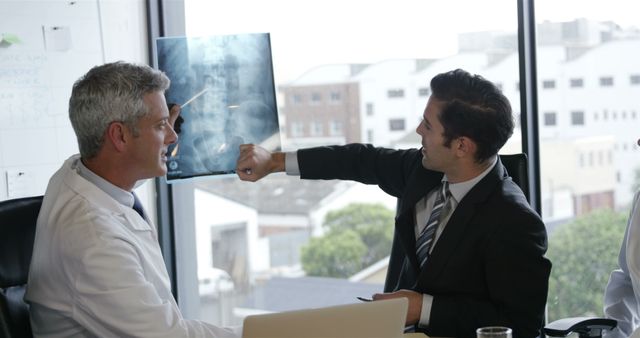 Doctor and Businessman Discussing X-Ray Results in Modern Office - Download Free Stock Images Pikwizard.com