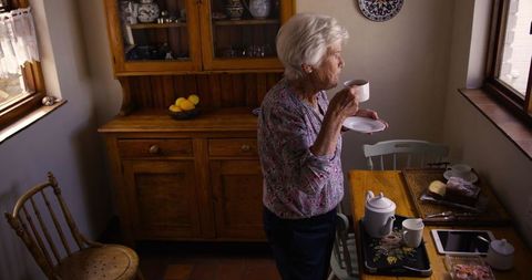 Senior woman enjoying coffee in cozy kitchen at home