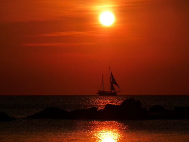 Silhouette of Sailboat at Sunset Over Ocean - Download Free Stock Photos Pikwizard.com