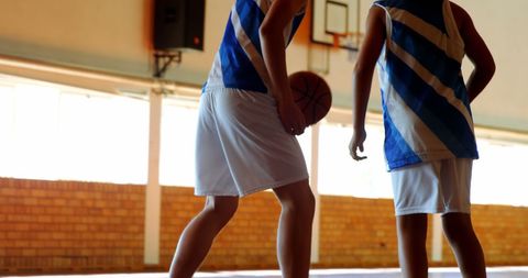 Young Athletes Practicing Basketball in Indoor Court