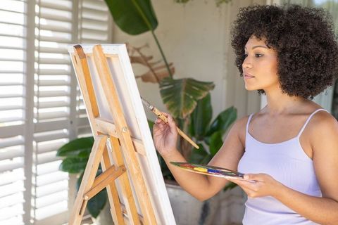 Artist Painting on Easel in Bright Home Studio