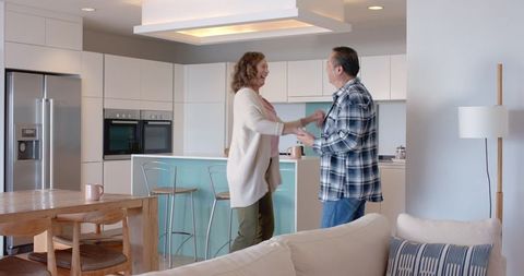 Senior Couple Celebrating in Modern Kitchen with Joyful Dance