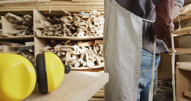 Carpenter in Workshop Tying Apron Near Wooden Planks Shelves - Download Free Stock Images Pikwizard.com