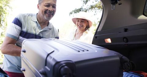 Senior Couple Packing Luggage for a Sunny Outdoor Adventure