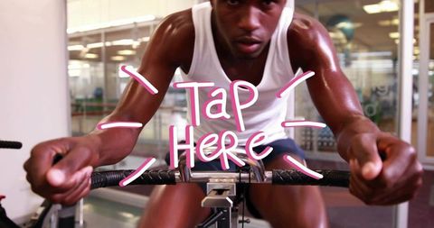 Intense indoor cycling workout athlete pedaling gripping handlebars pink tap here overlay