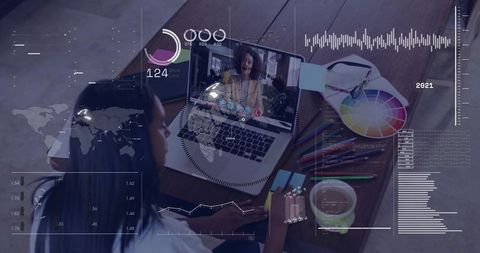 Woman joining video call at desk with color wheel, pencils and data HUD overlay