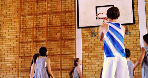 Young Athletes Playing Basketball Indoors with Focus