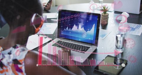 Businesswoman Analyzing Financial Graphs on Laptop in Office