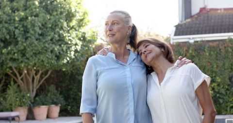 Female Friends Embracing Outdoors on Sunny Patio