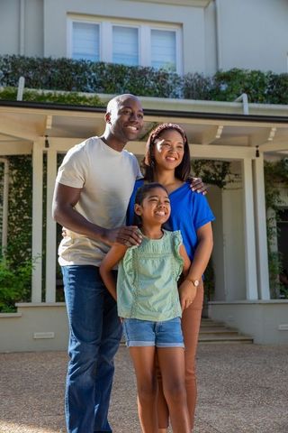 Smiling family on suburban porch embracing outdoor lifestyle