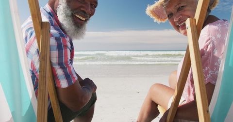Senior Couple Enjoying Relaxation on Sunny Beach Chairs