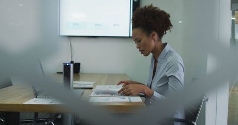 Focused businesswoman analyzing work documents in modern office