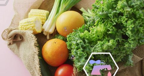 Displaying rustic produce still life with curly kale, oranges, corn and spring onions on pink table