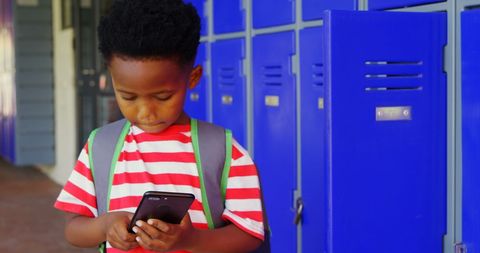 Young Student Texting in School Hallway