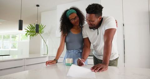 Happy Couple Planning Ideas Together in Modern Kitchen
