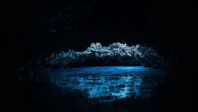 Glowing jagged rock ledge reflecting vivid cobalt blue light on calm pool inside sea cave
