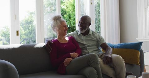 Senior Couple Relaxing on Couch at Home in Bright Living Room