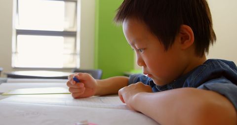Focused Asian Schoolboy Drawing in Classroom - Download Free Stock Images Pikwizard.com