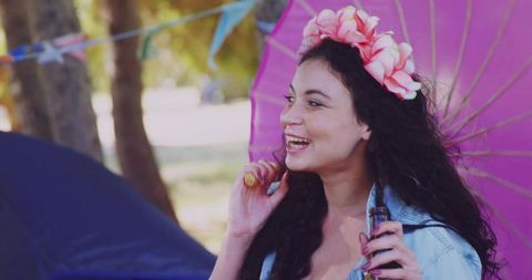 Smiling Woman with Parasol and Spray Bottle at Outdoor Festival