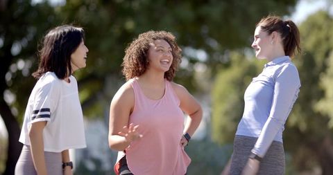 Diverse Women Enjoying Outdoor Conversation with Fitness Trackers in Park