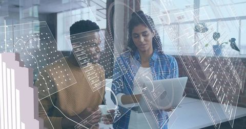 Coworkers analyzing data with digital innovations in modern office