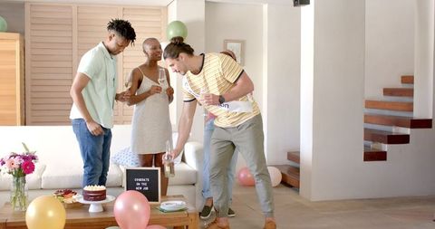 Friends celebrating new job milestone with champagne at home