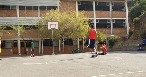 Players Engaged in Outdoor Basketball Game at School