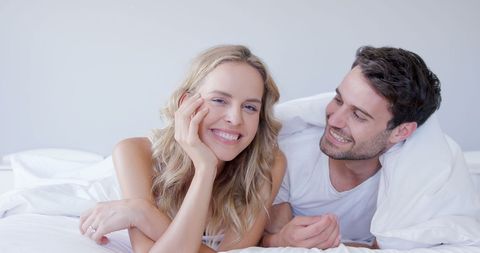 Happy Couple Relaxing Under Bed Sheets